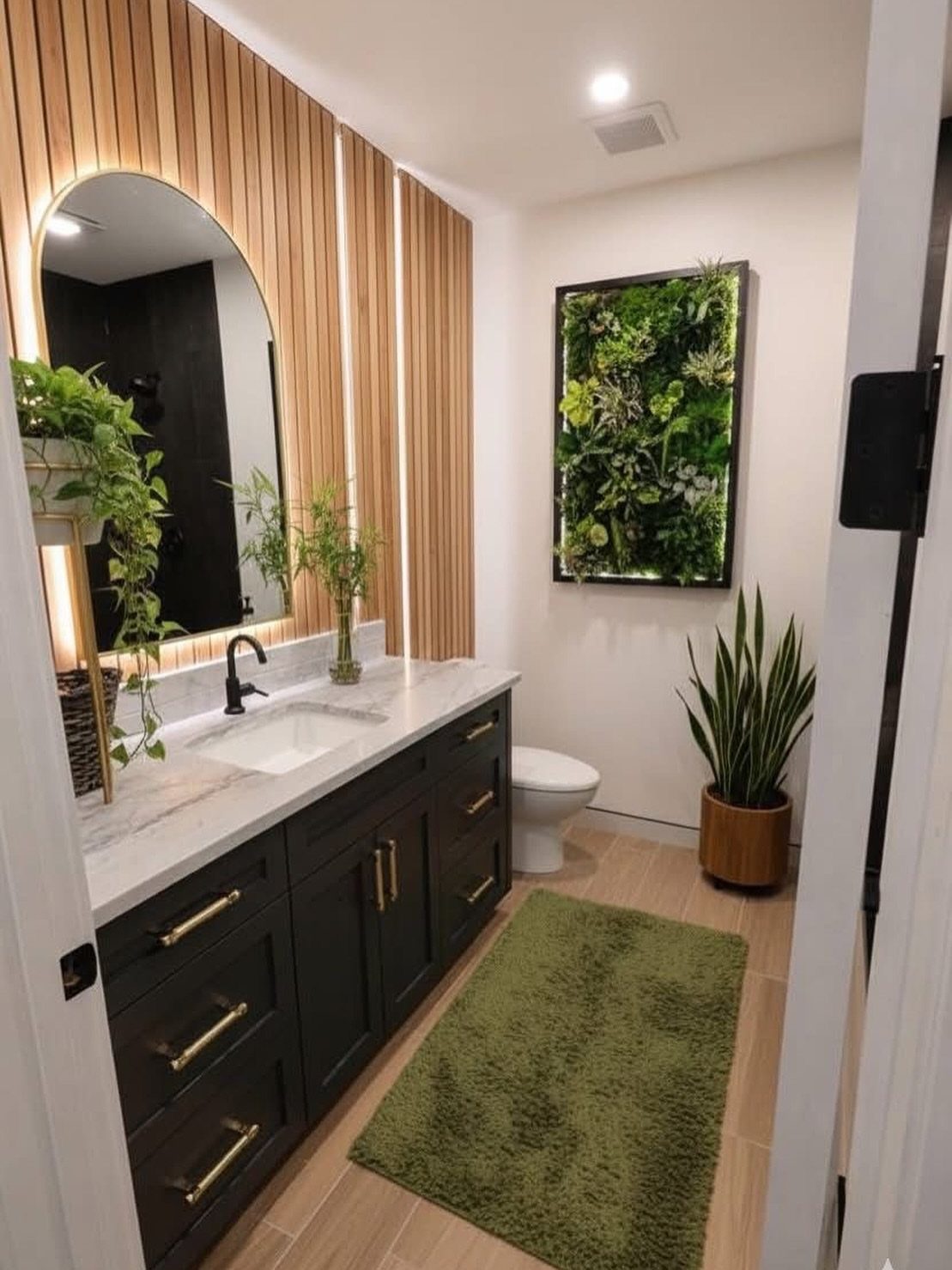 Small bathroom with a vertical plant wall, wood paneling, and dark vanity.
