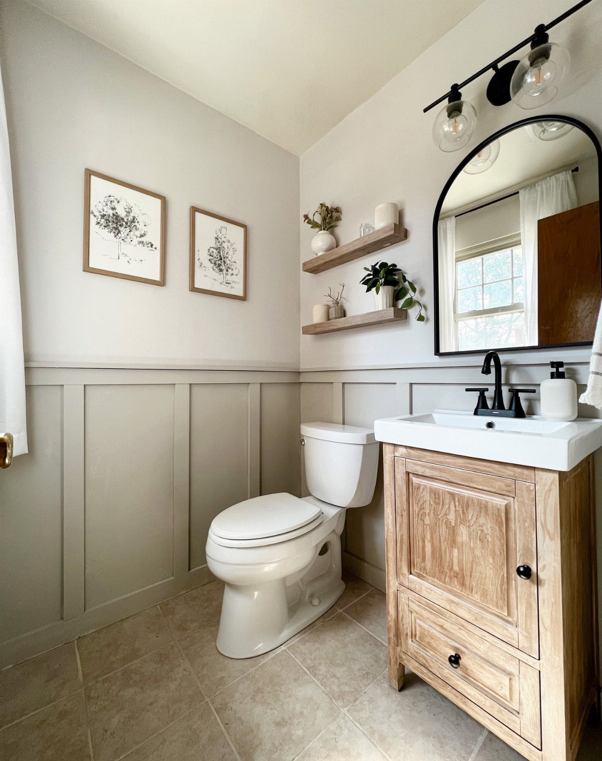Small powder room with grey board-and-batten wainscoting, light wood vanity, and white toilet.