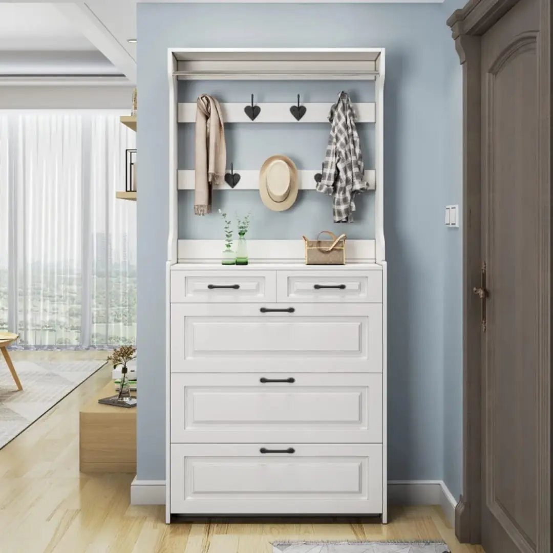 White wooden entryway storage unit with coat hooks and drawers against blue wall