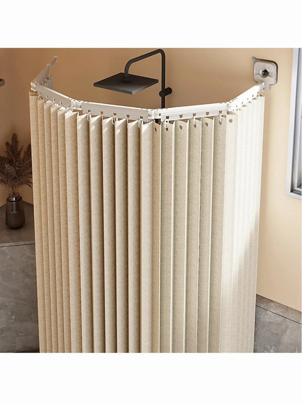 Beige pleated shower curtain with a curved white rod and black showerhead.