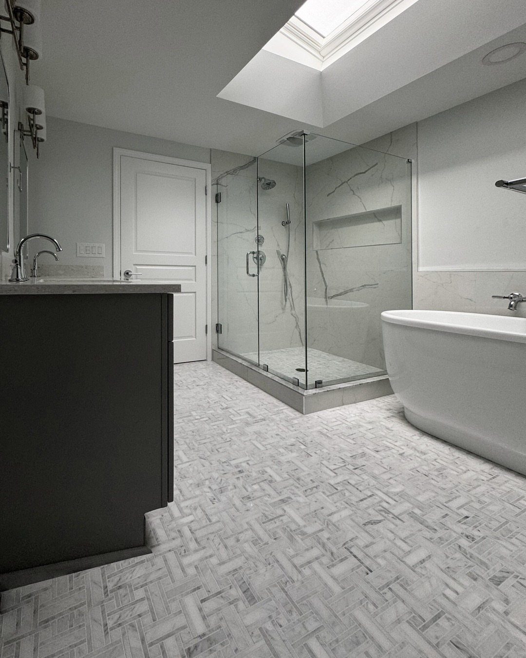 Modern bathroom with a glass shower located directly beneath a bright ceiling skylight.