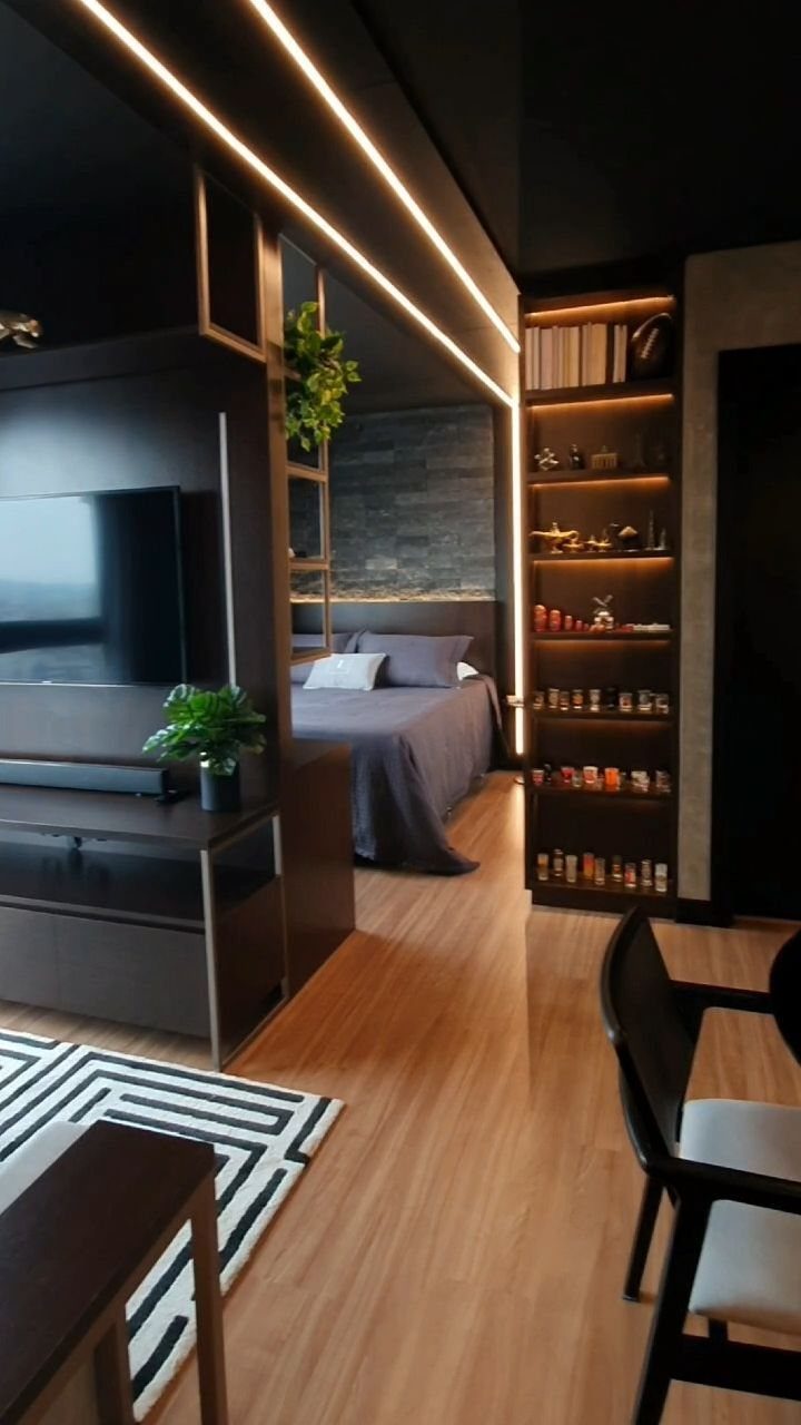 Modern studio apartment with dark wood furniture, integrated ceiling lighting, and zoned living areas.