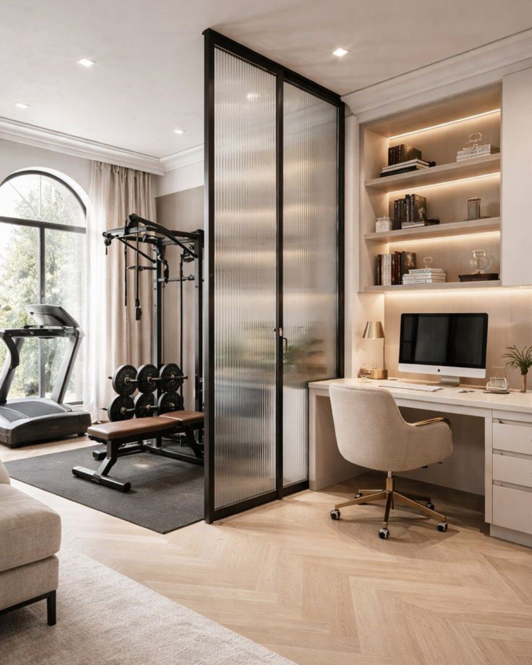 Home office desk nook separated from a gym area by fluted glass partition