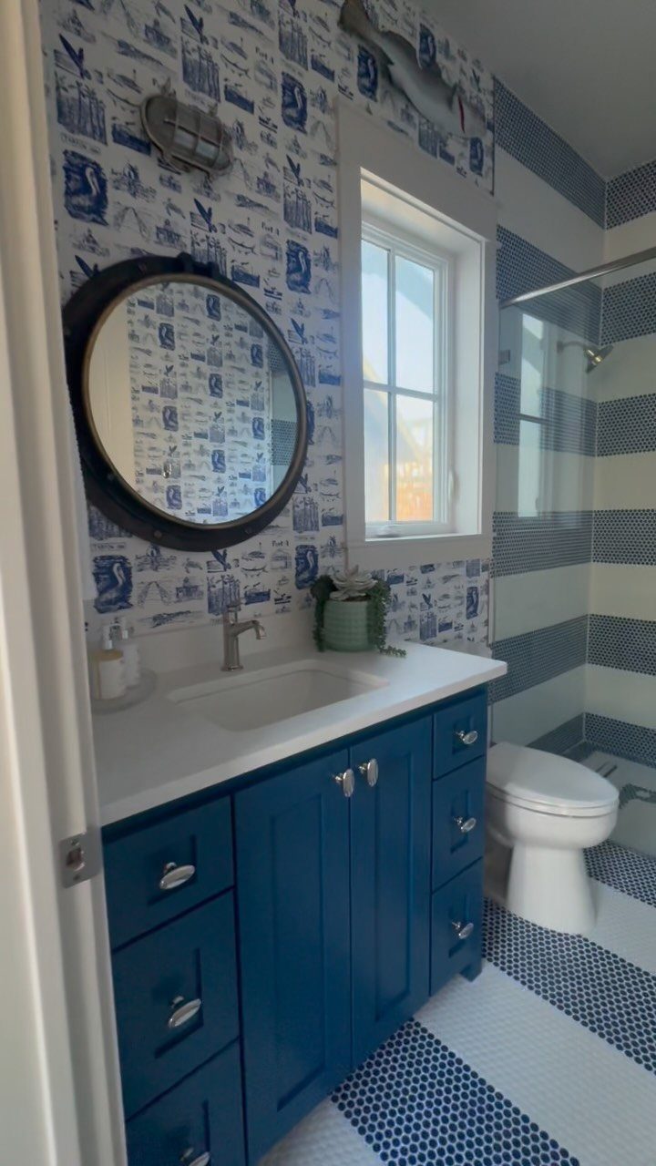 Blue and white patterned floor tiles in a bathroom with a blue vanity.